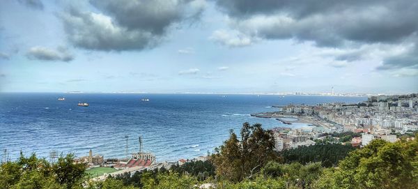 High angle view of townscape by sea against sky