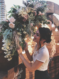Side view of smiling woman standing by decorations