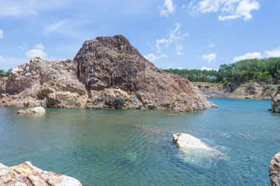 Rock formations in sea against sky