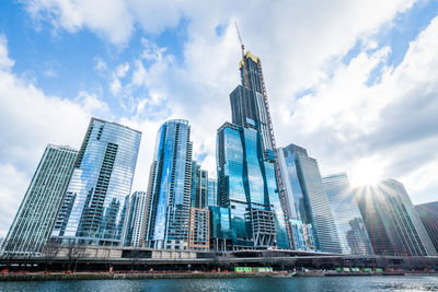 Low angle view of modern buildings against cloudy sky