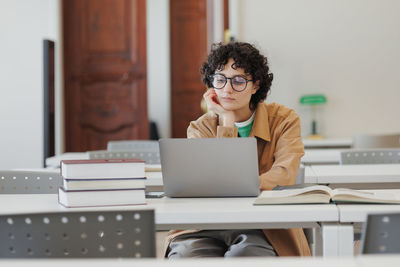 Young businesswoman using laptop at desk in office