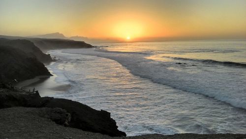 Scenic view of beach against sky during sunset