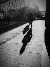 Silhouette people walking on road in city