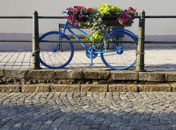 Bicycle parked by railing on footpath