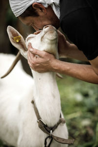 Local agriculture, farmer's day 12 october. a man with a goat in his arms,  natural products.