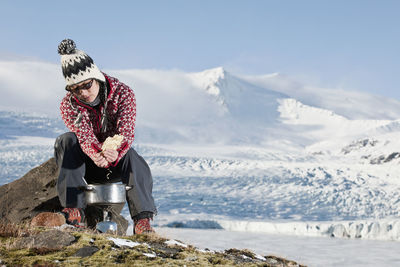 Man with umbrella on snowcapped mountains during winter