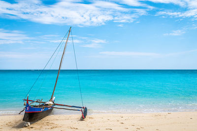 Sailboat on beach against sky