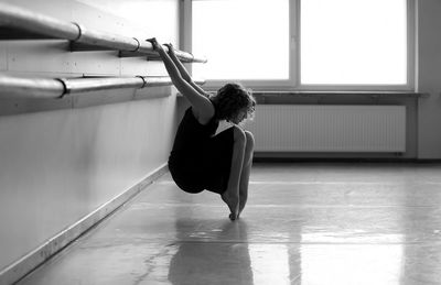 Teenage girl stretching at ballet studio
