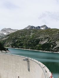 Scenic view of lake by mountains against sky