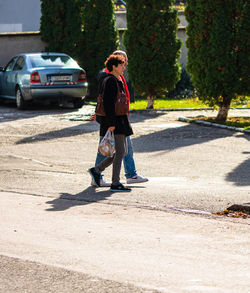 Full length of boy on road in city