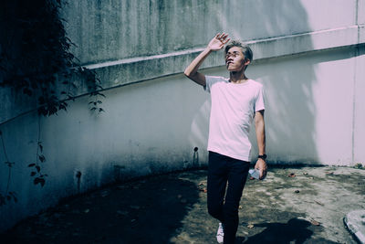 Full length of man standing against wall