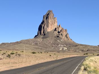 Rock formations in desert against clear blue sky