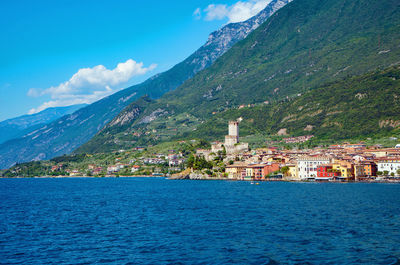 Scenic view of sea by buildings in town against sky
