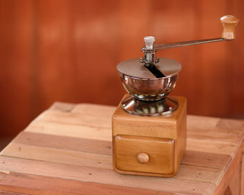 Close-up of vintage coffee grinder on wooden table