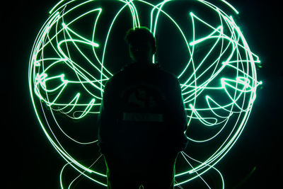 Silhouette man with light painting at night