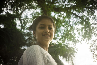 Portrait of woman against trees in forest