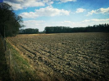 Scenic view of field against cloudy sky