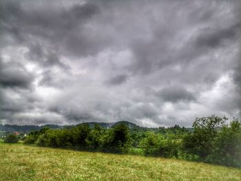 Scenic view of field against cloudy sky