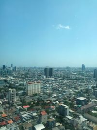 High angle view of city buildings against clear blue sky