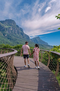 Rear view of woman walking on footbridge