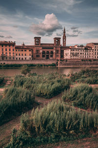 Buildings in city against cloudy sky