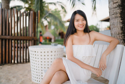 Portrait of smiling young woman sitting on seat