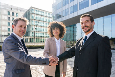 Business colleagues standing against building