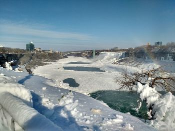 Snow covered landscape against clear blue sky