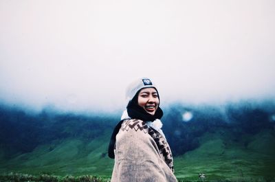 Portrait of smiling man standing in foggy weather