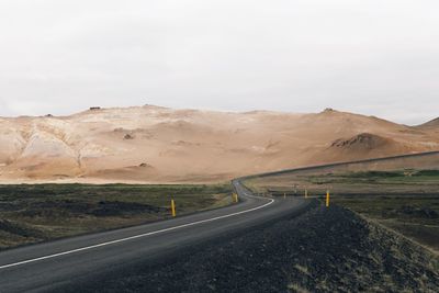 Empty road leading towards mountains