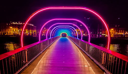 Illuminated bridge over river at night