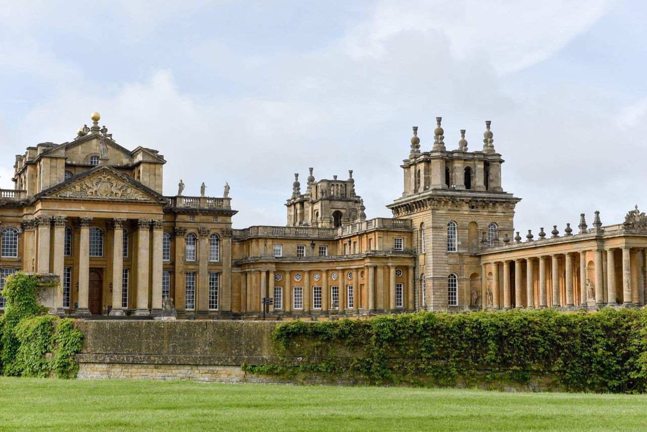 architecture, built structure, building exterior, grass, famous place, history, sky, travel destinations, cloud - sky, statue, facade, lawn, tourism, plant, the past, architectural column, museum, pediment, memories, outdoors, baroque style, culture, day, spire, government building