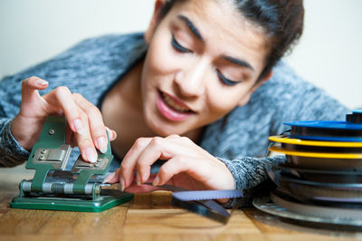 Young woman working on old splicer machine at table