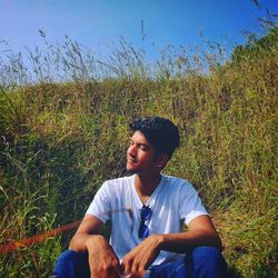 Young man sitting on field, nature lover
