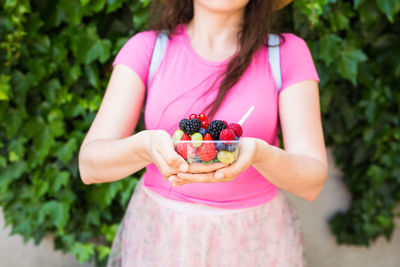 Midsection of woman holding fruits