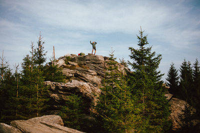 Low angle view of man standing on mountain against mountains