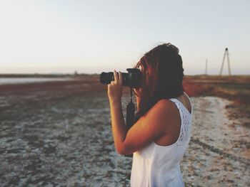 Side view of man photographing on beach