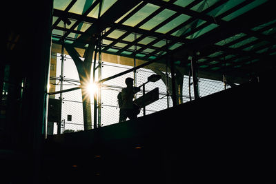 Low angle view of silhouette man standing by window