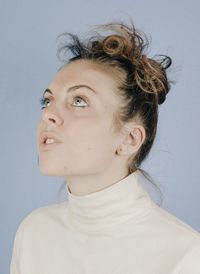 Close-up portrait of young woman against white background