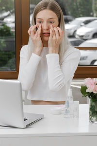 Self face massage on-line course near laptop. woman doing anti-age massage near computer. young