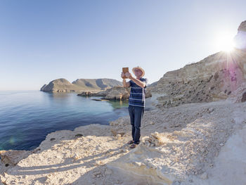 Spain, andalusia, cabo de gata, man taking a selfie at the sea
