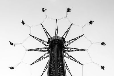 Low angle view of chain swing ride against sky