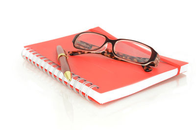 High angle view of eyeglasses on book against white background