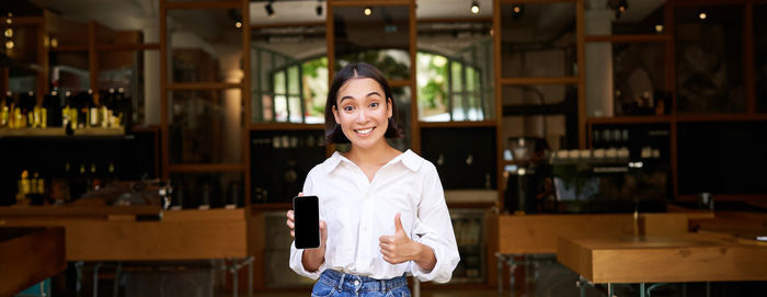 Portrait of young woman standing in store