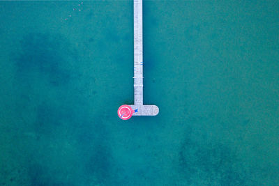 Drone shot of a pier with an umbrella on sea