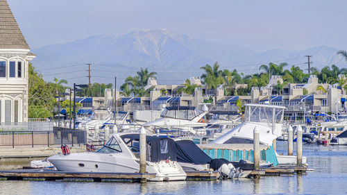 Sailboats moored in sea against sky