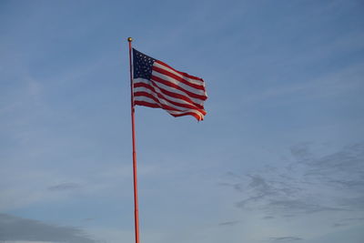 Low angle view of flag against blue sky