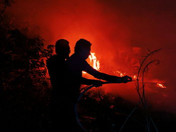 Silhouette of man with fire crackers at night