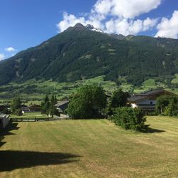 Scenic view of green landscape and mountain against sky