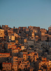 Buildings in city against clear sky